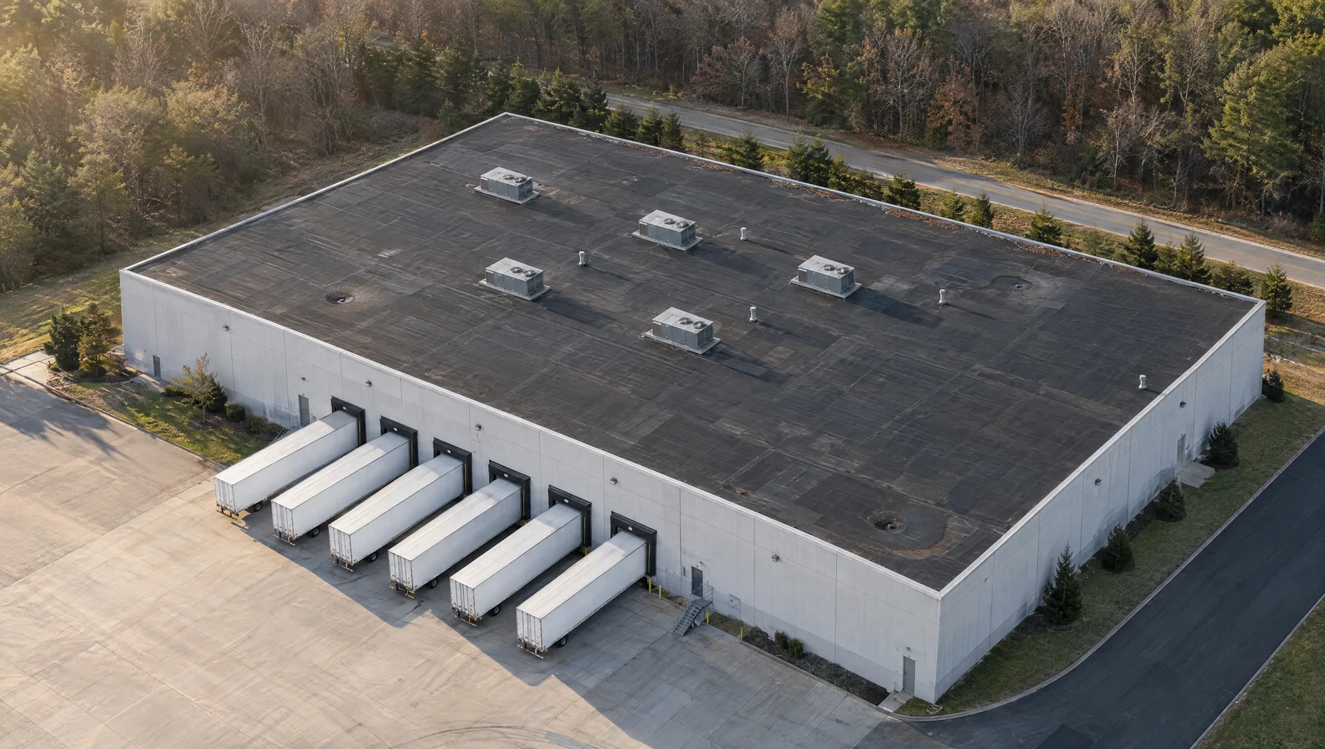 Process visualization: one commercial warehouse transforms from a worn roof to a restored white silicone roof.